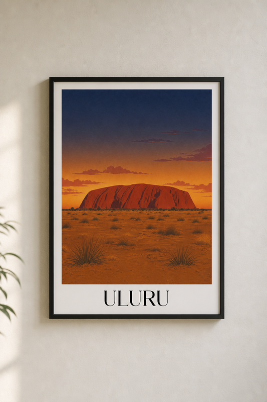Framed artwork of Uluru at sunset on a white wall.